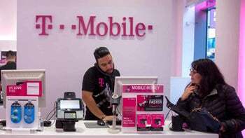 یک نماینده T-Mobile به مشتری در داخل یک فروشگاه خرده فروشی کمک می کند.