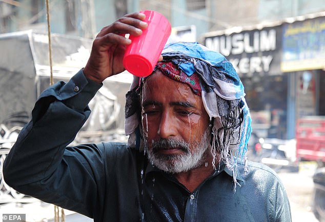 مردی خود را با یک فنجان آب در یک اردوگاه کنار جاده ای که توسط گروه اجتماعی Sohni Dharti شورای جوانان در حیدرآباد ، پاکستان اداره می شود ، خنک می کند
