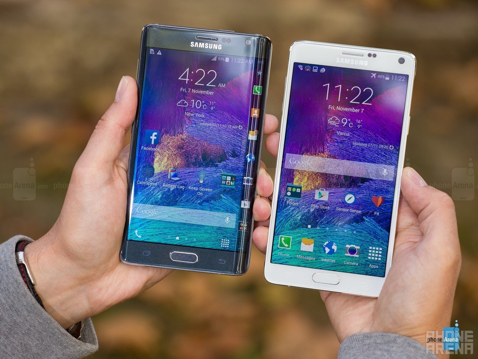 سامسونگ Galaxy Note Edge و Galaxy Note 4 ، که در دست برگزار می شود ، به سمت دوربین می رود. آنها روشن هستند و صفحه اصلی را با تصاویر پس زمینه بنفش نشان می دهند