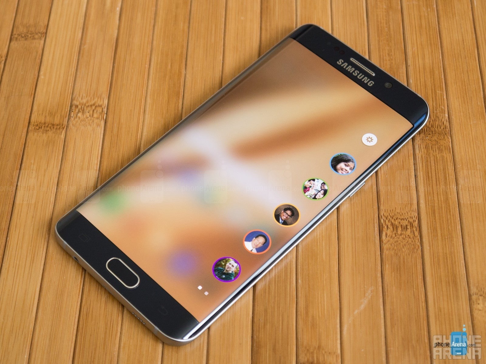 سامسونگ Galaxy S6 Edge+، روی یک میز دراز کشیده ، صفحه نمایش روشن است و یک صفحه لبه با مخاطبین مورد علاقه روی صفحه کشیده می شود